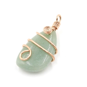 Detail of green natural crystal pendant with handcrafted rose gold wire wrapping art
