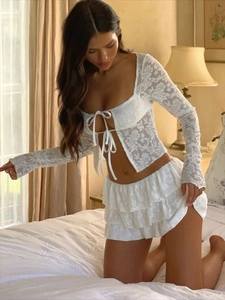 Sexy white lace two-piece set featuring long sleeve tie-up crop top and ruffled mini skirt