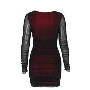 Détail d'une robe en tulle dégradé rouge et noir avec texture plissée et manches
