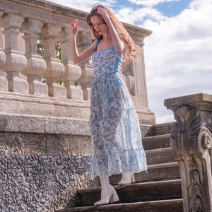 Floral print long tiered dress with square neck and blue patterns in outdoor setting