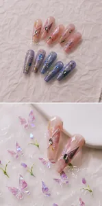 Macro detail of handmade 3D butterfly and floral nail stickers with glitter and rhinestones