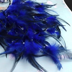 Close-up of deep blue feathers and decorative beads on a tree of life dream catcher