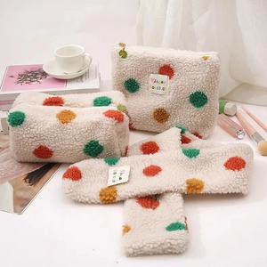 Detailed set of polka dot sherpa makeup bags and headband on a minimalist vanity desk