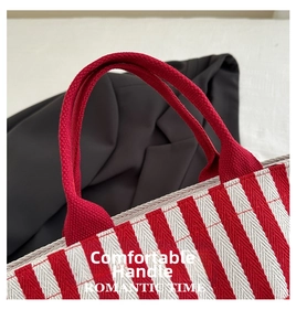 Detail of red and white striped canvas tote bag with durable braided rope handles