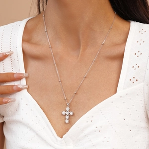 Elegant silver cross pendant necklace with white pearls and satellite chain on model