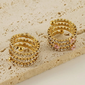 Elegant multi-layer gold plated ring with sparkling zircons on a beige travertine base