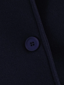 Detailed macro view of dark blue wool fabric texture and matching round button
