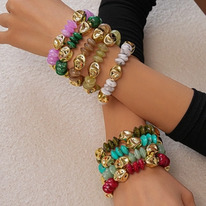 Close-up of bohemian irregular acrylic beads and textured gold beads on a bracelet