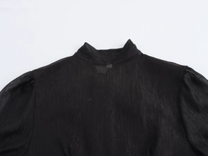 Détail du dos d'une robe en mousseline noire avec des manches bouffantes