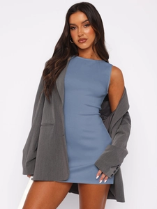 Détail de robe moulante bleue sans manches avec une veste blazer grise oversize