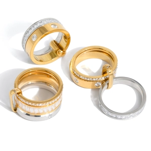 Macro shot of 18K gold and silver stainless steel rings with buckle design and cubic zirconia