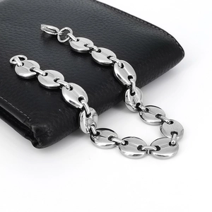 Dettaglio del bracciale a chicco di caffè argento 11mm su un portafoglio nero