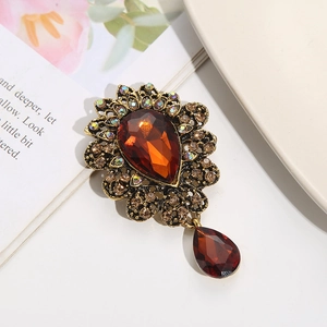 Detail of vintage flower brooch with amber crystal teardrop and champagne rhinestones