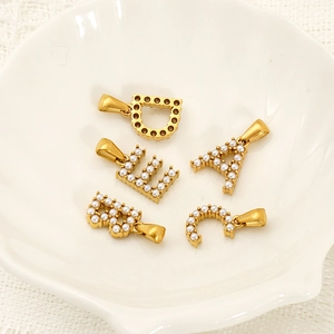 Pendentif lettre doré avec micro-perles sur plateau coquille et fond en dentelle