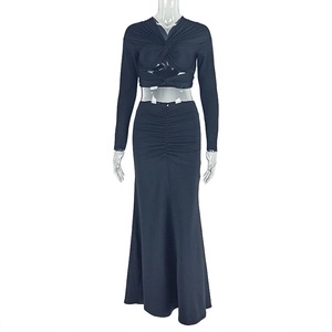 Detail view of the black two-piece set featuring twisted cropped top and ruched maxi skirt