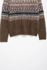 Detail of soft brushed knit texture with Fair Isle geometric patterns on a brown sweater
