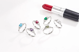 Close-up of heart-shaped crystal rings in various colors with shiny silver finish