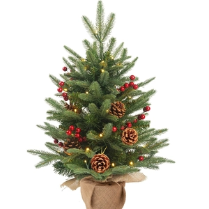 Close-up of mini Christmas tree with pine cones, red berries and warm LED lights