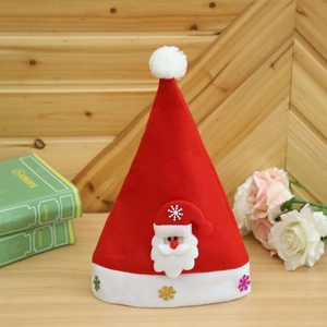 Classic red Christmas hat with plush Santa applique and snowflake trim on wood background
