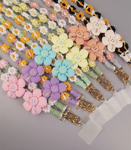 Detailed shot of handmade woven daisy phone lanyards in pink, blue and yellow