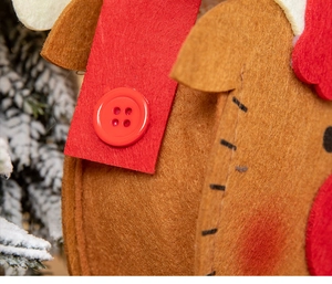 Detailed close-up of brown felt Christmas bag with red button and fine stitching