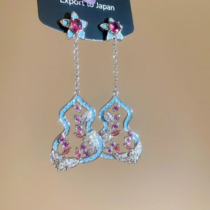 Makroaufnahme der Silber-Ohrhänger mit Zirkon-Blume und hohlem Flaschenkürbis-Design