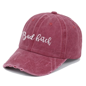 Detailed close-up of vintage distressed burgundy baseball cap with Bad Bitch embroidery