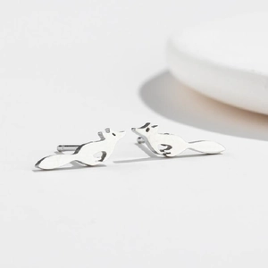 Macro shot of silver fox studs featuring a polished finish on a clean white surface
