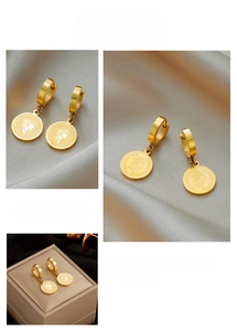 Macro detail of gold coin pendant earrings featuring queen portrait on silk background