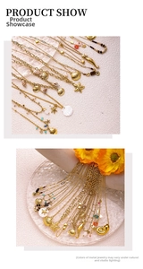 Détail de colliers marins dorés ornés de coquillages et perles sur fond texturé doux