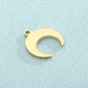 Minimalist gold crescent moon pendant in polished stainless steel on blue background