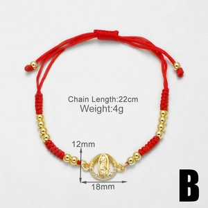 Macro detail of red woven bracelet with gold Virgin Mary pendant and zircon stones