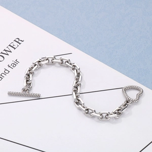 Detailed macro view of silver rectangular link chain bracelet with heart T-bar closure