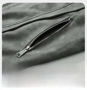 Detail view of smooth metal zipper pocket on dark gray suede vintage jacket