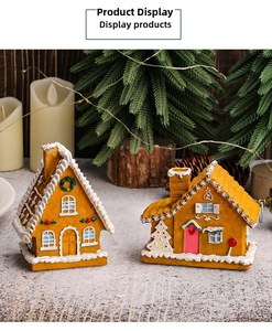 Detail view of two resin Christmas gingerbread houses with LED lights and snow coating