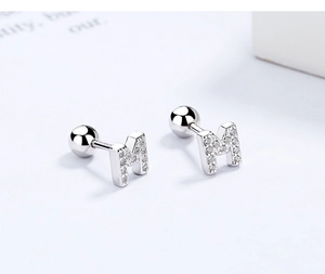 Detailed macro of S925 sterling silver letter M stud earring with sparkling cubic zirconia