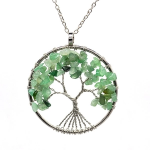 Close-up of handmade Tree of Life pendant with green natural crystal stones and silver wire