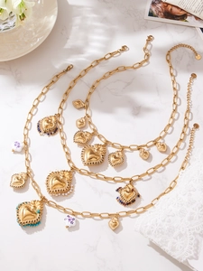 Détails de trois colliers en acier doré avec des pendentifs en forme de cœur et perles
