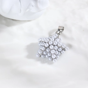Détail d'un pendentif en forme d'étoile serti de perles blanches sur surface texturée