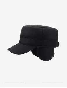 Detail of winter thermal flat cap showing earflaps and metal logo on thick wool fabric