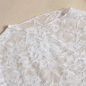 Close-up of white floral lace neckline showing detailed hollow-out embroidery texture