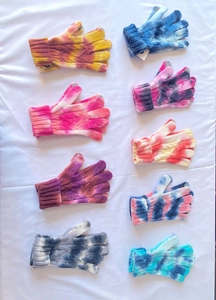 Detail of colorful tie-dye knitted gloves with ribbed cuffs in various bright color patterns