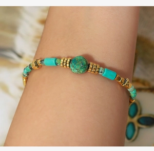 Detailed close-up of Bohemian turquoise beaded bracelet with golden metallic spacer accents