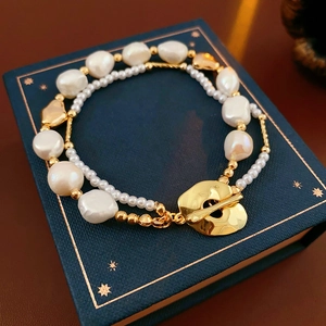 Detail of double-layer freshwater pearl bracelet with golden OT buckle and baroque pearls