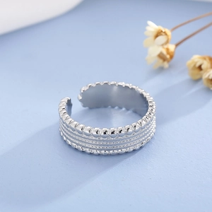 Detailed close-up of adjustable silver ring featuring woven tire texture and beaded edges