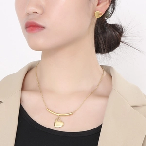 Golden stainless steel heart pendant necklace and stud earrings set on a model