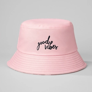 Detail of pink cotton bucket hat featuring black Good Vibes script embroidery