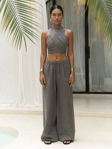 Detail of taupe two-piece set featuring cross halter crop top and linen wide-leg pants
