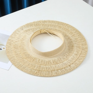 Top view of beige straw sun hat with frayed edge and woven texture details