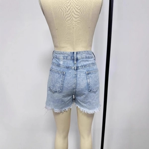 Detail view of denim shorts with distressed frayed hem and back pockets on light blue wash